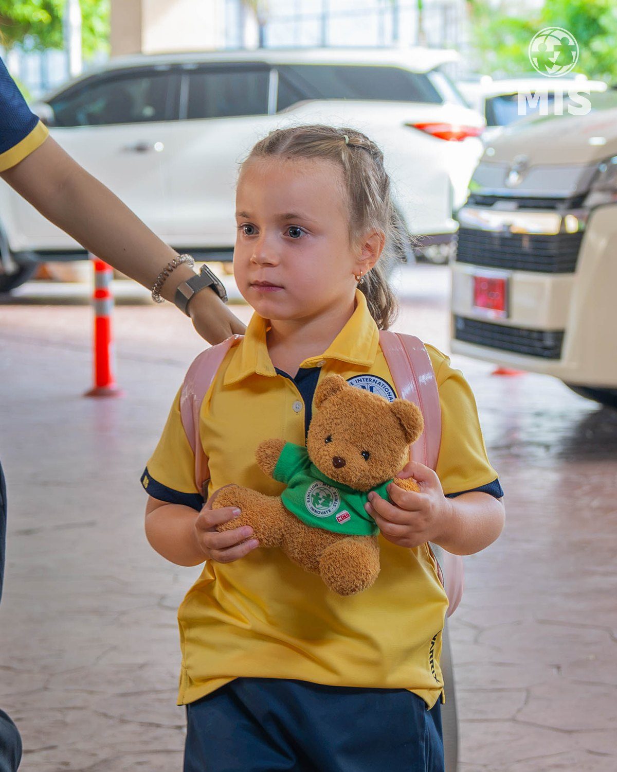 Teacher welcoming a child and parent at drop-off