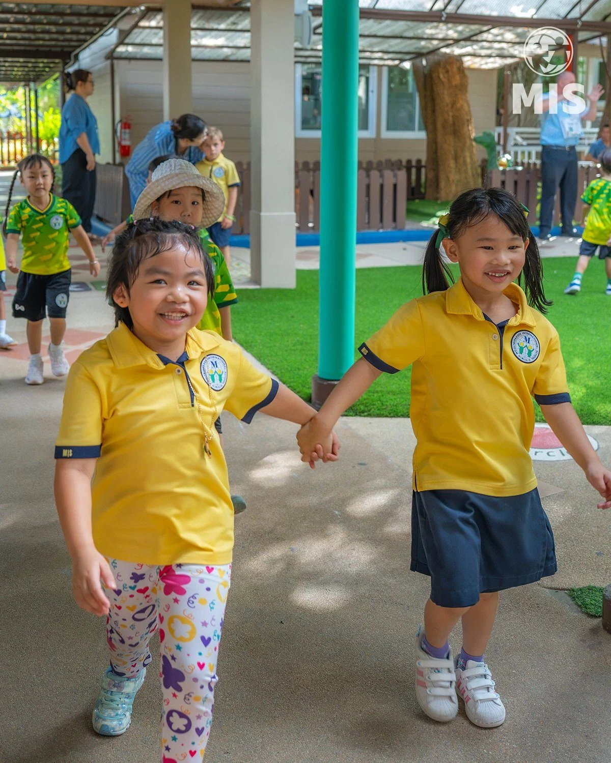 Children walking across the green campus
